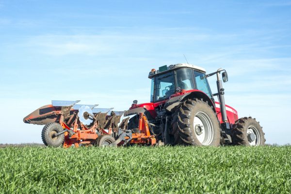 Tractor agricultural machine cultivating field.